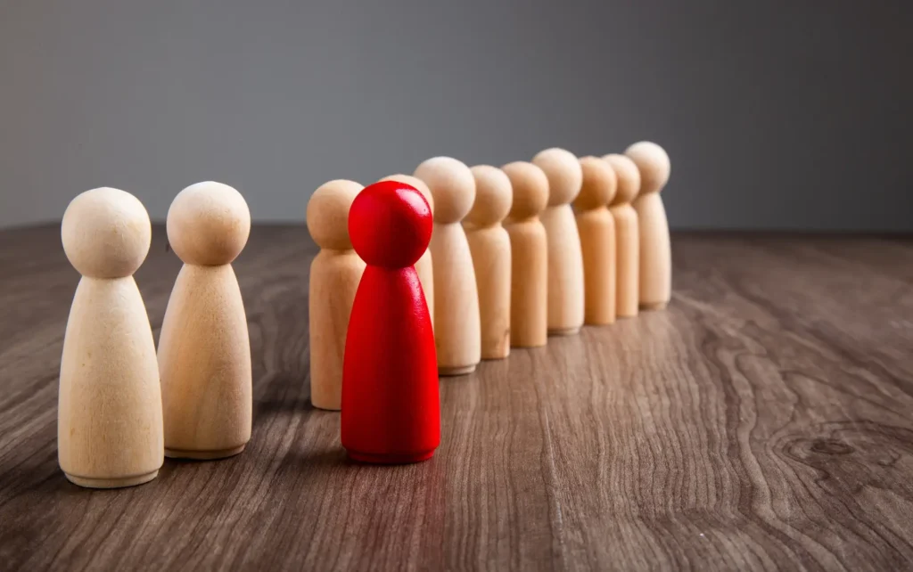 Wooden people figures on wooden background. Career growth, development and leadership